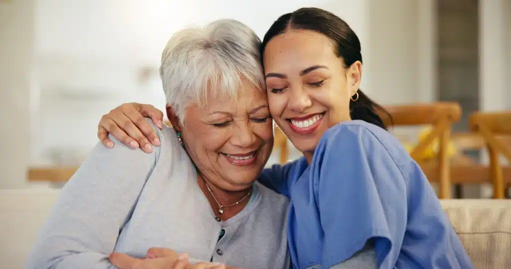 Happy older woman sitting next to her live-in care attendant