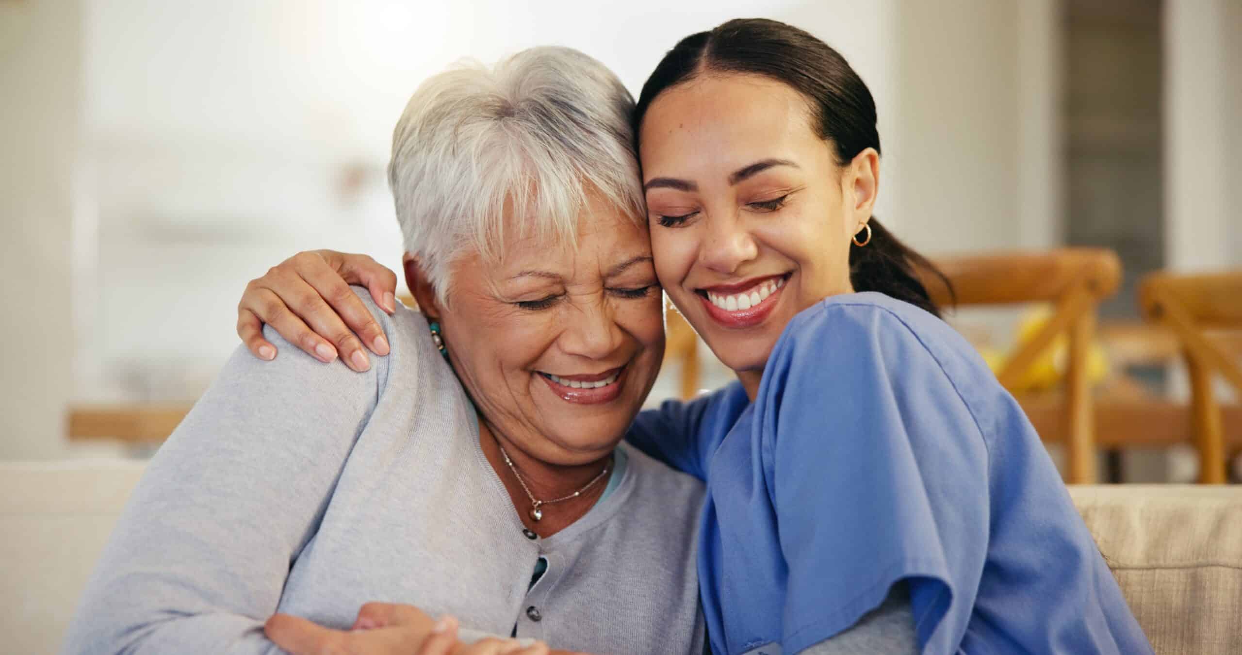 Happy older woman sitting next to her live-in care attendant