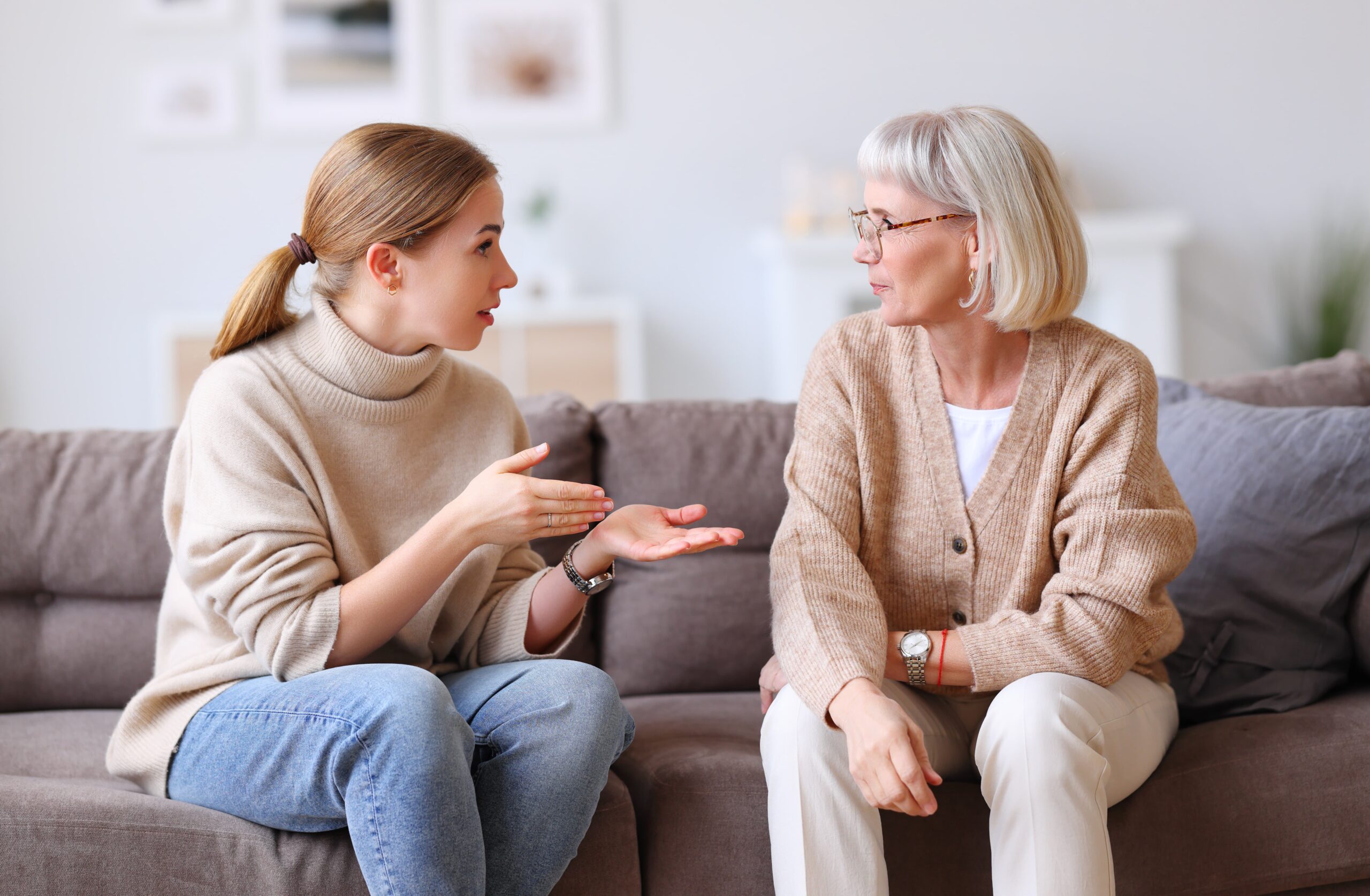 adult woman encouraging her aging mother to talk about suspicious encounters