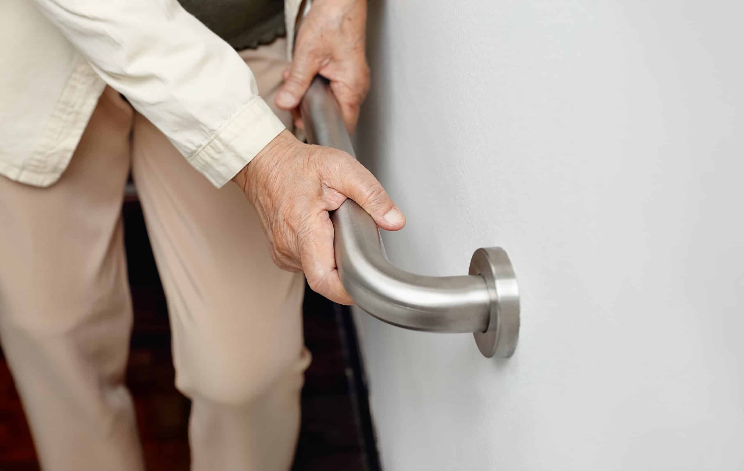 Senior using handbar getting up from the bathroom