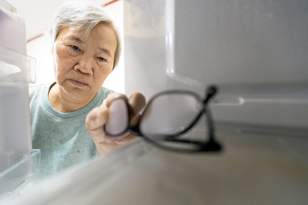 elderly man finding his glasses in the fridge