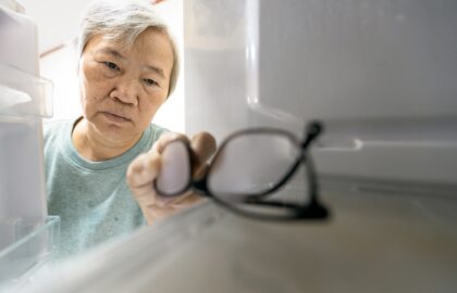 elderly man finding his glasses in the fridge