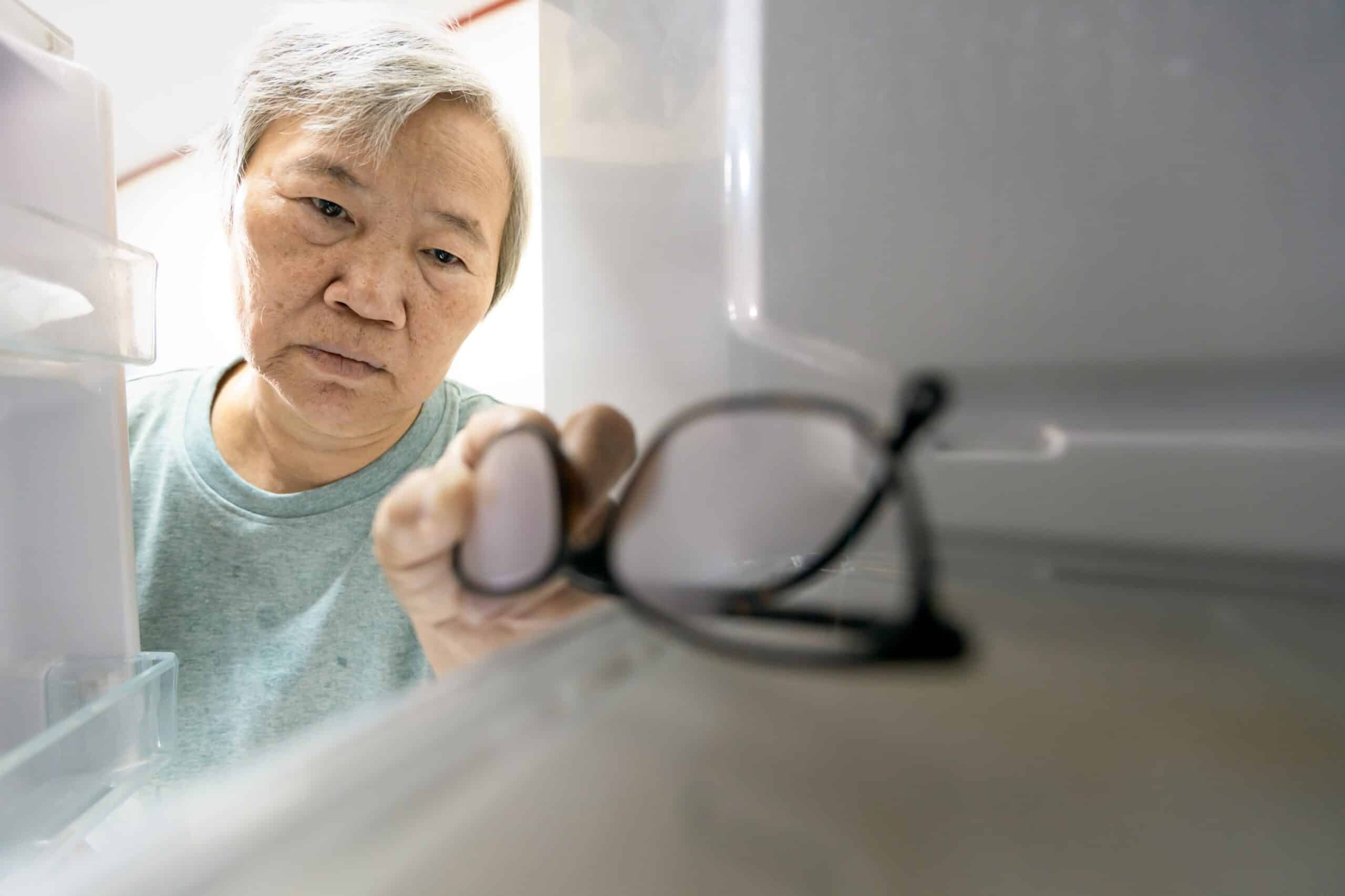 elderly man finding his glasses in the fridge