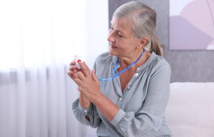 Elderly woman pushing on the button of her medical alert system
