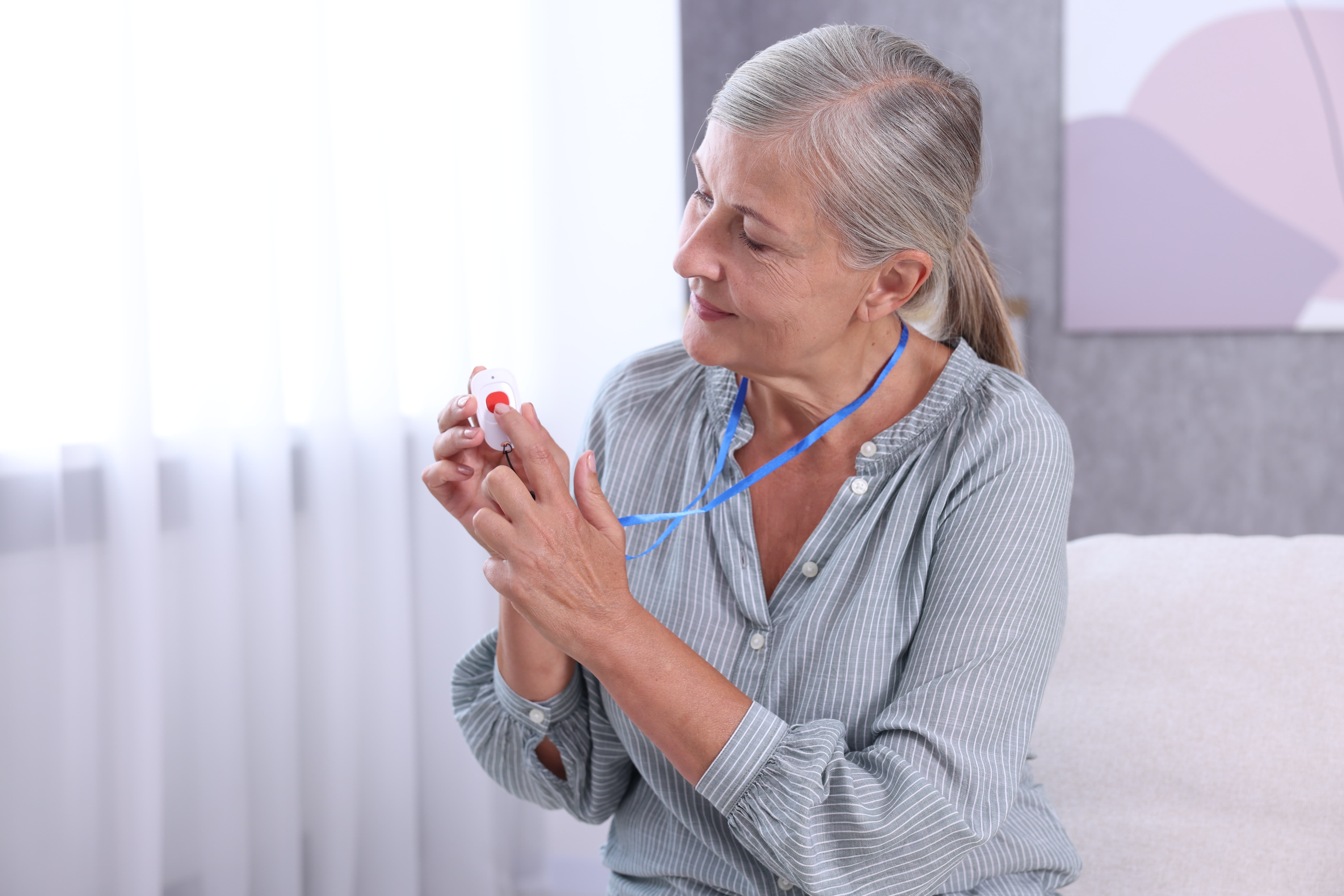 Elderly woman pushing on the button of her medical alert system